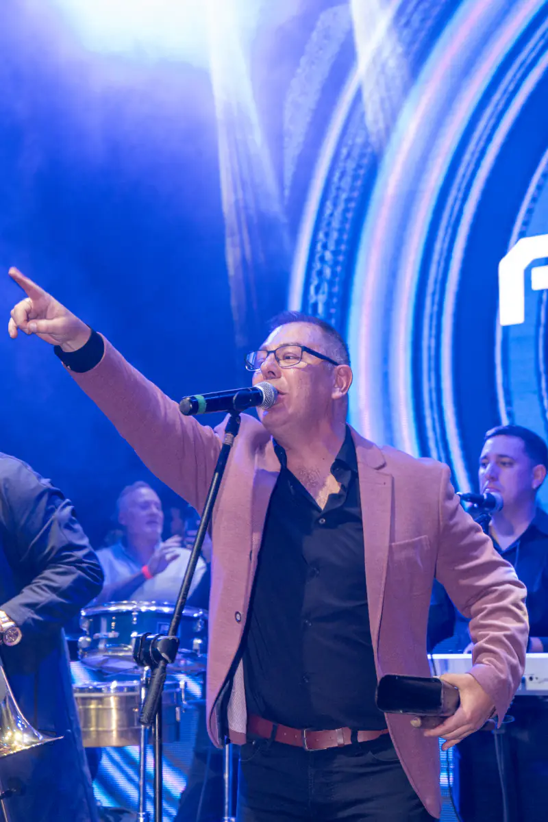 Cantante señalando al público en pleno show, luces azules